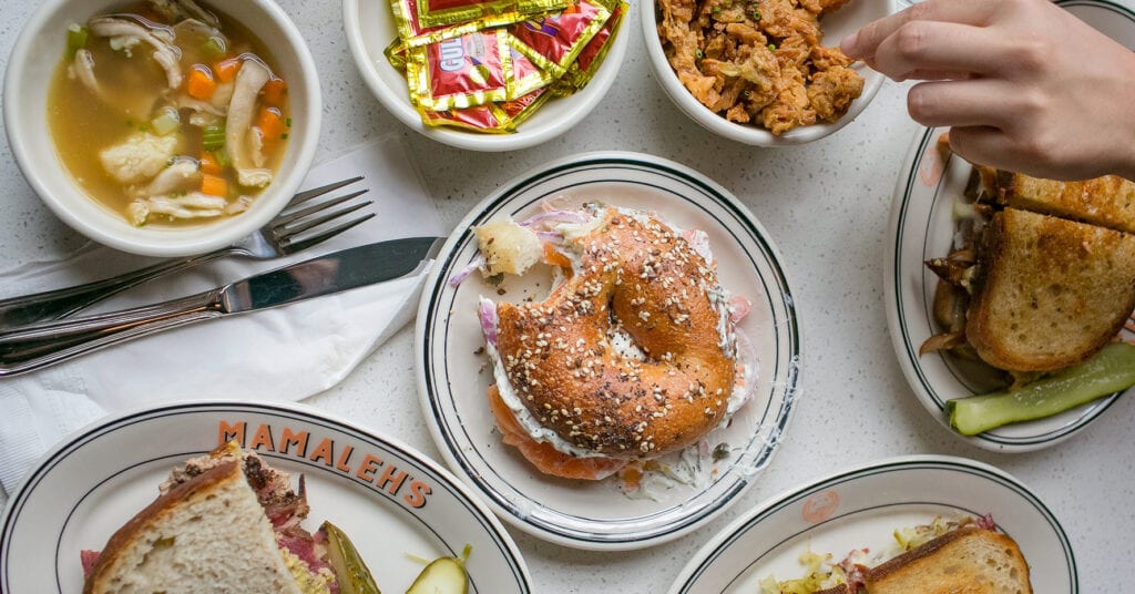 Overhead view of a table will Mamaleh's bagels, sandwiches and soups.