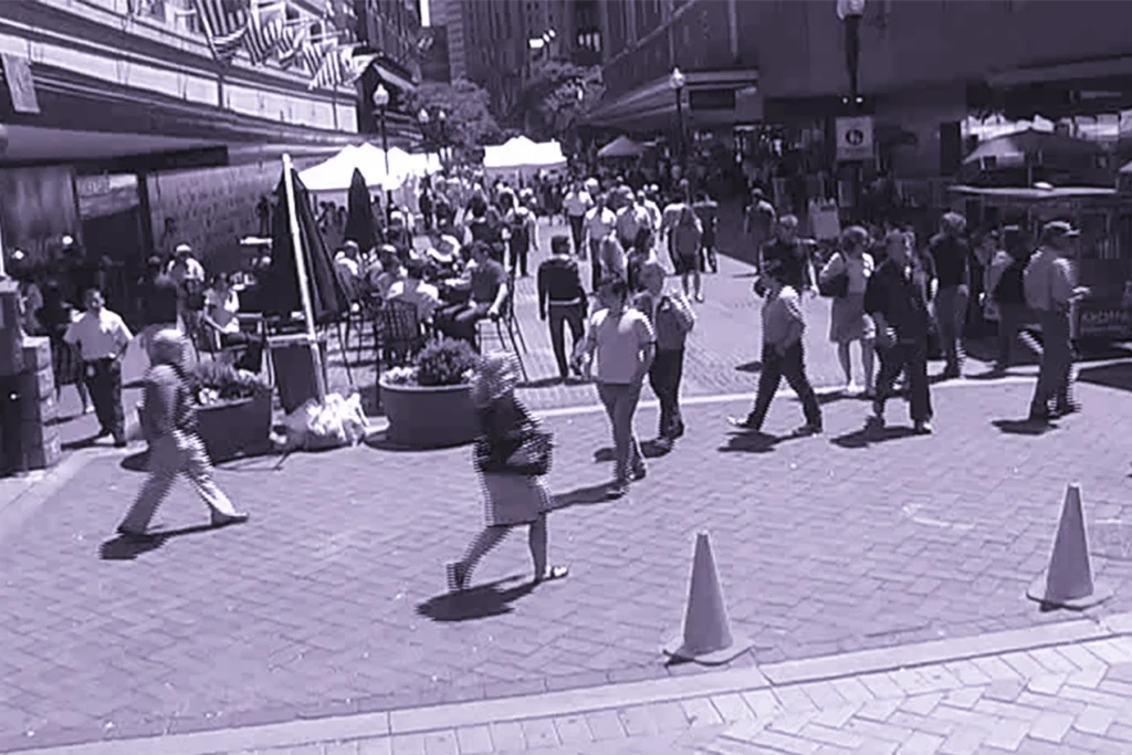 a crowd of people walking in a public space in Boston